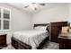 Bedroom with a dark wood frame bed, light gray bedspread, ceiling fan, and shuttered window with natural light at 4701 S Siphon Draw Rd, Apache Junction, AZ 85119