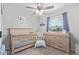 Bright Bedroom showcasing a wooden crib, changing table, and ceiling fan for comfortable living at 4815 W Charleston Ave, Glendale, AZ 85308