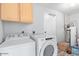 Practical laundry room with washer, dryer, and overhead cabinets for efficient storage at 4815 W Charleston Ave, Glendale, AZ 85308