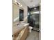 Modern bathroom features dark tiled shower, sleek vanity and neutral finishes at 4911 E Amelia Ave, Phoenix, AZ 85018