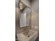 Stylish powder room with stone counter, decorative mirror, and elegant lighting fixture at 4911 E Amelia Ave, Phoenix, AZ 85018