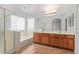 Well-lit bathroom featuring a dual sink vanity, a tub, and a glass-enclosed shower at 5123 W Novak Way, Laveen, AZ 85339