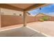 A covered patio featuring a brick-paved area that leads to a gravel area enclosed by a block wall for privacy at 5123 W Novak Way, Laveen, AZ 85339