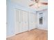 This light blue bedroom features wood floors, white closets and a ceiling fan at 6101 W Sunnyside Dr, Glendale, AZ 85304