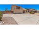 Charming home featuring a balcony, arched window, two-car garage, and desert landscaping at 6101 W Sunnyside Dr, Glendale, AZ 85304