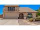 Charming home featuring a balcony, arched window, two-car garage, and low maintenance landscaping at 6101 W Sunnyside Dr, Glendale, AZ 85304