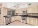 Modern kitchen features stainless steel appliances, light cabinetry, and a tile backsplash at 6101 W Sunnyside Dr, Glendale, AZ 85304