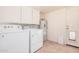 Clean laundry room with washer, dryer, storage cabinets, and tile flooring at 6101 W Sunnyside Dr, Glendale, AZ 85304