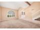 Spacious living room with vaulted ceilings, carpeted floors, and an arched window for lots of natural light at 6101 W Sunnyside Dr, Glendale, AZ 85304