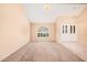 Spacious living room with vaulted ceilings, carpeted floors, and an arched window for lots of natural light at 6101 W Sunnyside Dr, Glendale, AZ 85304