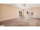 Bright, beige-walled living room leading to the kitchen with white appliances at 6101 W Sunnyside Dr, Glendale, AZ 85304