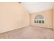 Spacious living room with vaulted ceilings, carpeted floors, and an arched window for lots of natural light at 6101 W Sunnyside Dr, Glendale, AZ 85304