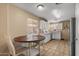 Bright kitchen with white cabinets, a stainless steel refrigerator, a round dining table, and natural light at 612 E Racine Pl, Casa Grande, AZ 85122
