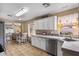 Well-lit kitchen with white cabinetry, a stainless steel dishwasher, and a breakfast nook flowing into the living area at 612 E Racine Pl, Casa Grande, AZ 85122
