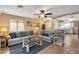 Open-concept living room with tile flooring, a ceiling fan, and comfortable sofas, seamlessly connecting to the kitchen at 612 E Racine Pl, Casa Grande, AZ 85122