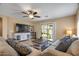 Bright living room featuring a ceiling fan, comfortable seating, and sliding glass doors to the backyard patio at 612 E Racine Pl, Casa Grande, AZ 85122