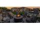 Backyard lounge area with a fire pit and comfortable seating, complemented by a well-manicured lawn and the home's facade at 6320 E Gloria Ln, Cave Creek, AZ 85331