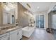 Luxurious bathroom featuring a stand-alone tub, mosaic tile wall, pendant lighting, and double doors to a private patio at 6320 E Gloria Ln, Cave Creek, AZ 85331