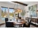 Dining room with a round wooden table, black leather chairs, decorative chandelier and pool view at 6320 E Gloria Ln, Cave Creek, AZ 85331