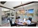 Dining room with a round wooden table, black leather chairs, decorative chandelier and pool view at 6320 E Gloria Ln, Cave Creek, AZ 85331