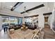 Expansive living room features dark wood beams, a ceiling fan, and sliding glass doors leading to an outdoor pool and living area at 6320 E Gloria Ln, Cave Creek, AZ 85331
