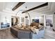 Spacious living room featuring wood beams, modern decor, hardwood floors, and a large sectional couch at 6320 E Gloria Ln, Cave Creek, AZ 85331