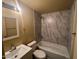 Updated bathroom featuring a new vanity, mirror, lighting, tub, and shower with marble tile at 6447 W Piccadilly Rd, Phoenix, AZ 85033