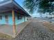 Side-view of exterior featuring covered porch and simple desert rock landscaping at 6447 W Piccadilly Rd, Phoenix, AZ 85033