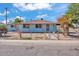 Charming exterior showcasing a well-kept blue home with a security gate and mature trees at 6447 W Piccadilly Rd, Phoenix, AZ 85033