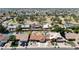 A high-angle aerial view of a neighborhood showing houses, yards, and a park area with mature trees at 6457 E Encanto St, Mesa, AZ 85205