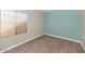 Bright room with wood flooring, painted accent wall, and bright window at 6457 E Encanto St, Mesa, AZ 85205