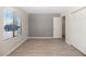Bright bedroom with wood-look floors and white trim featuring a large window at 6457 E Encanto St, Mesa, AZ 85205