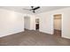 Spacious carpeted bedroom with a ceiling fan and neutral walls features an ensuite bathroom at 6457 E Encanto St, Mesa, AZ 85205