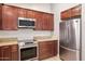 Close-up of kitchen with stainless steel appliances, granite countertops, and wood cabinetry at 6457 E Encanto St, Mesa, AZ 85205