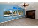 Bright living room features large windows overlooking the pool and wood-look flooring at 6457 E Encanto St, Mesa, AZ 85205