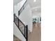 Modern staircase with sleek black metal railings and light wood floors leading to the upper level at 6743 N 9Th Dr, Phoenix, AZ 85013