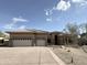Tan home with a three car garage, a tile roof, and desert landscaping with rocks and native plants at 6931 E Teton Cir, Mesa, AZ 85207