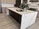 Modern kitchen island with white countertop and black base, light wood floors, and stainless steel appliances at 6931 E Teton Cir, Mesa, AZ 85207