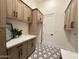 Well-organized laundry room with plenty of storage, modern fixtures, and patterned tile at 6931 E Teton Cir, Mesa, AZ 85207