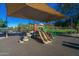 Community playground with slides, climbing structure, and shaded area on a sunny day at 6931 E Teton Cir, Mesa, AZ 85207
