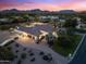 Expansive estate featuring a circular driveway, mature trees, and mountain views at sunset at 7129 E Caron Dr, Paradise Valley, AZ 85253