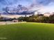 Expansive backyard with manicured lawn, lush landscaping, pool, and comfortable seating areas at 7129 E Caron Dr, Paradise Valley, AZ 85253