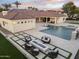 Luxury backyard featuring a pool, spa, fire pit, and lush landscaping, perfect for outdoor entertaining at 7129 E Caron Dr, Paradise Valley, AZ 85253