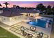 Luxury backyard with pool, spa, fire pit, and lush landscaping, creating a private oasis for relaxation and entertainment at 7129 E Caron Dr, Paradise Valley, AZ 85253