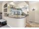 The wet bar has granite countertops, mirrored backsplash, and glass shelving for displaying drinks at 7129 E Caron Dr, Paradise Valley, AZ 85253