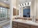 Neutral bathroom with decorative tile, a large mirror, and a shower/tub with glass enclosure at 7129 E Caron Dr, Paradise Valley, AZ 85253