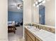 Bathroom with a large mirror reflecting the view into an adjacent bedroom with blue walls and carpet at 7129 E Caron Dr, Paradise Valley, AZ 85253