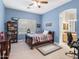 Charming bedroom with blue walls, ceiling fan, and a window, alongside a built-in bookshelf at 7129 E Caron Dr, Paradise Valley, AZ 85253