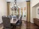 Elegant dining room boasting a large wooden table, upholstered chairs, a chandelier, and large windows with shutters at 7129 E Caron Dr, Paradise Valley, AZ 85253