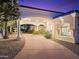 Inviting driveway and walkway leading to a grand home with lush landscaping at twilight at 7129 E Caron Dr, Paradise Valley, AZ 85253